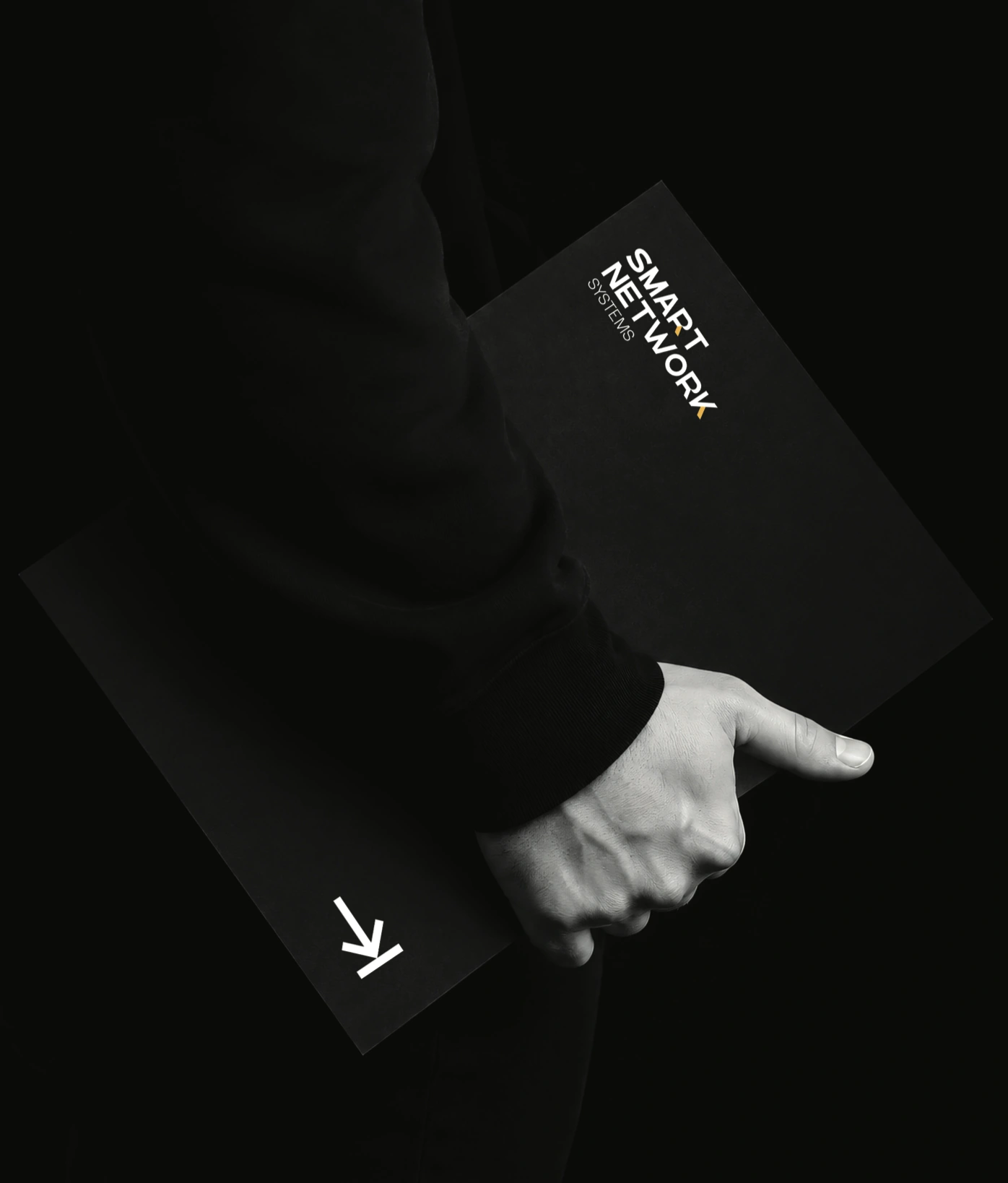 A black Smart Network Systems presentation folder held in one hand, with a white wordmark, yellow accents and arrow symbol