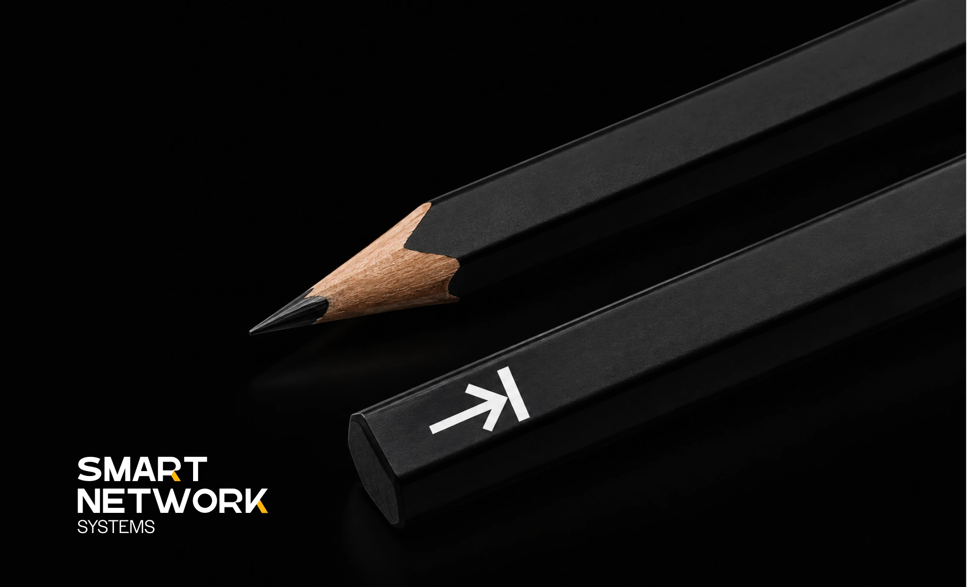 Black pencils carrying the white Smart Network Systems arrow symbol